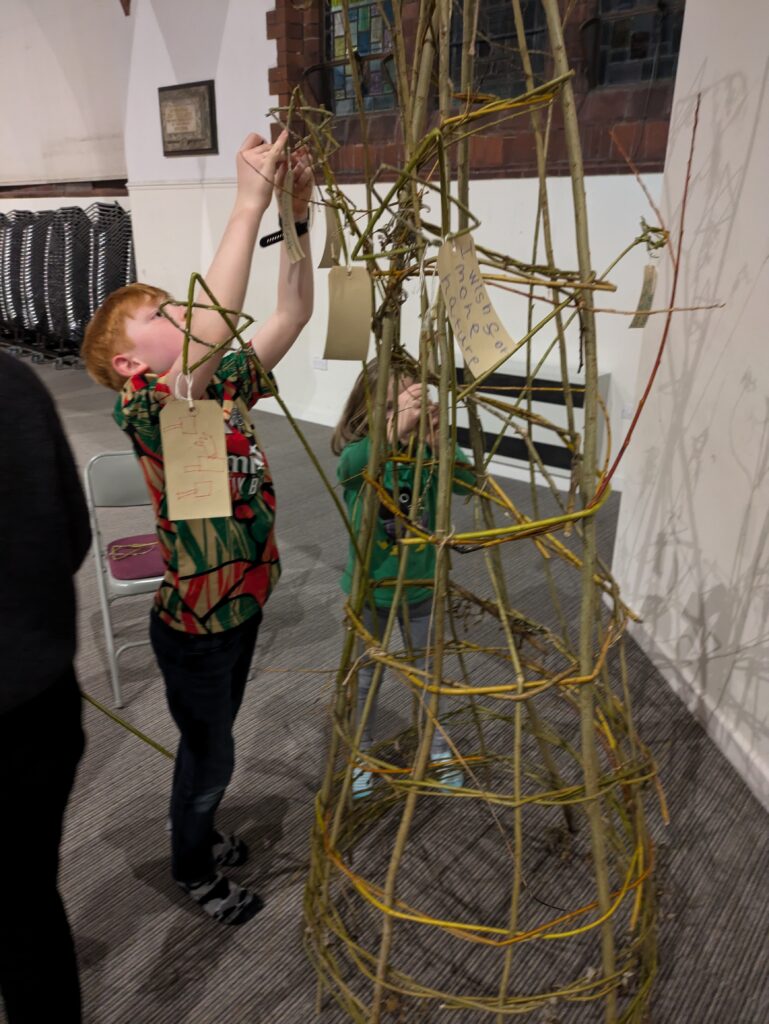 Luggage labels and willow stars attached to the tree by over 200 children, from age 3 to 16 at schools and Woodcraft Folk